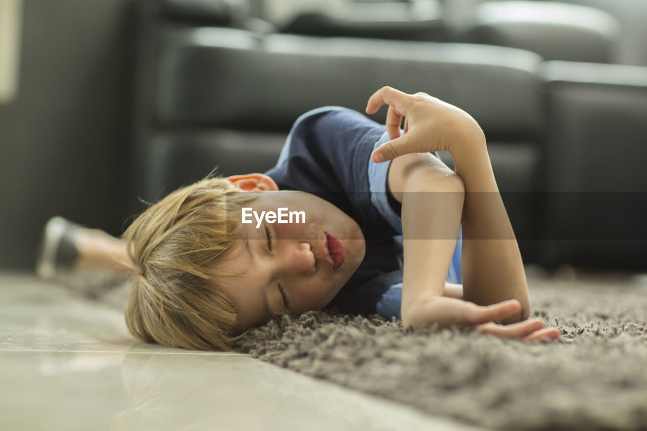 Boy sleeping on carpet at home