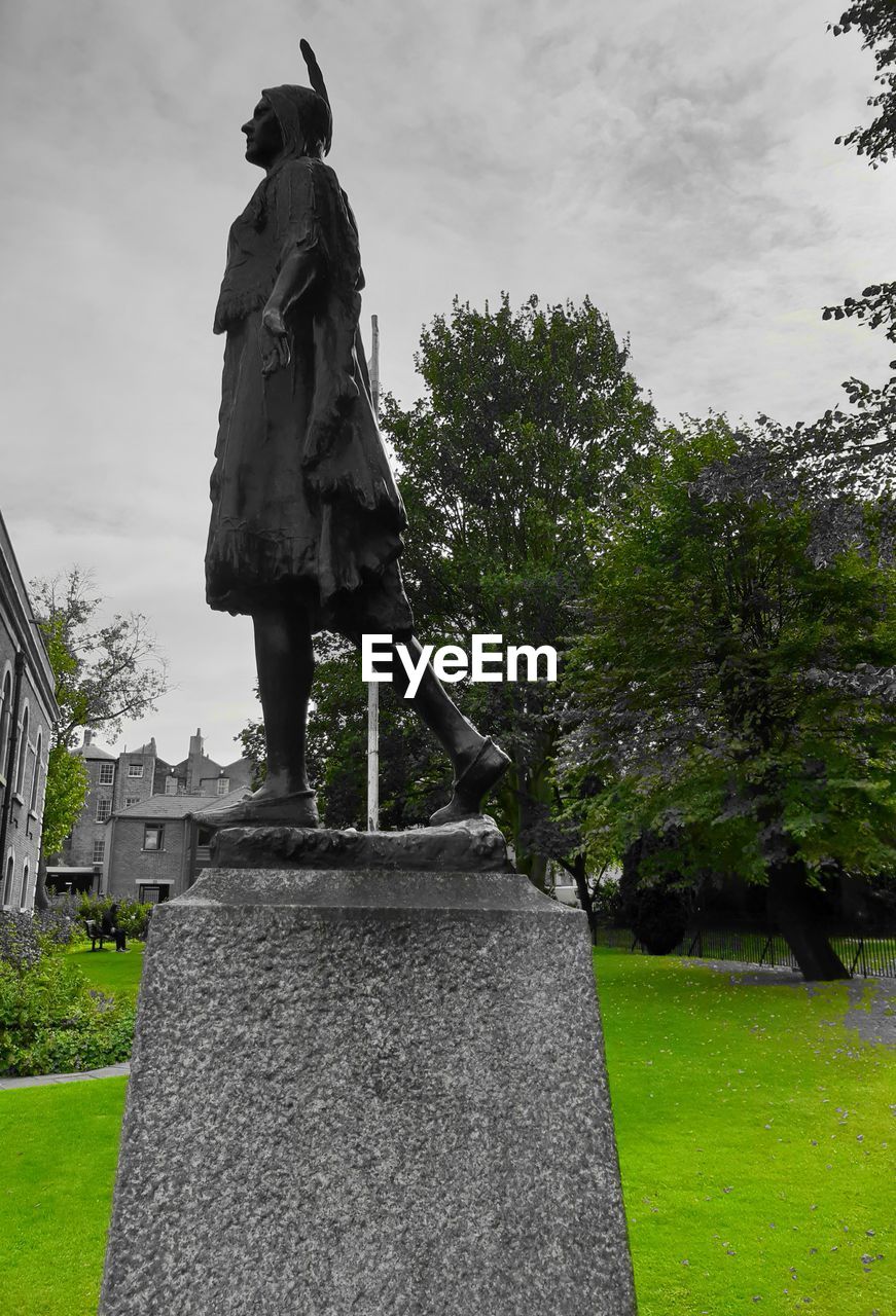 STATUE AGAINST TREES