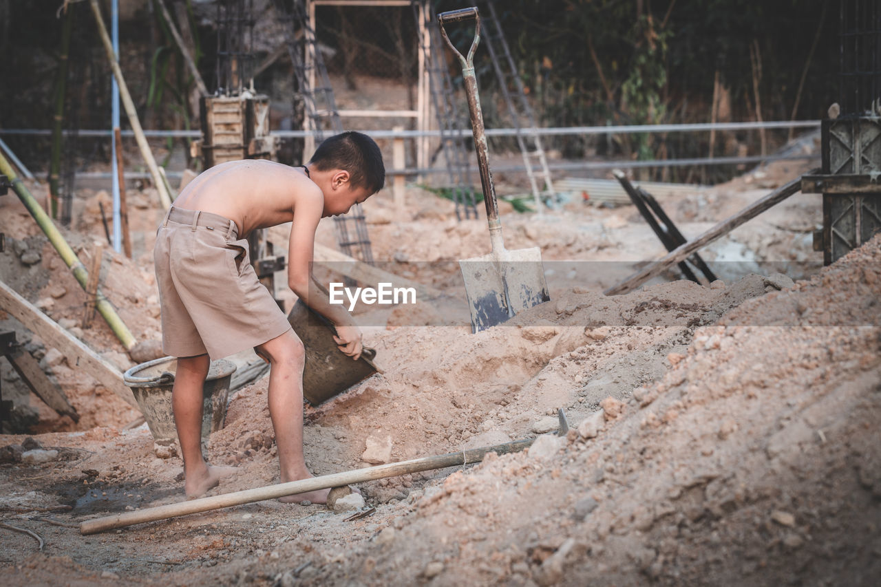 SIDE VIEW OF MAN WORKING IN CONSTRUCTION SITE
