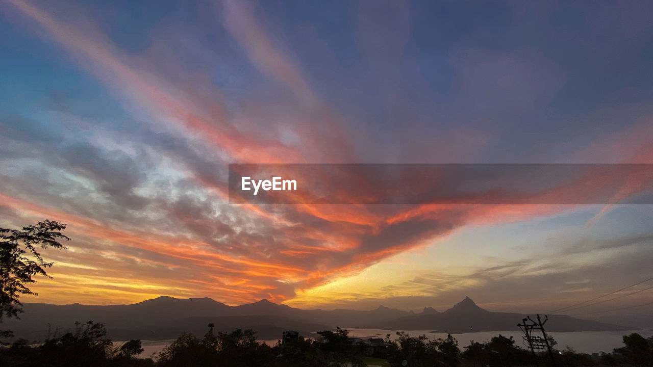 SCENIC VIEW OF DRAMATIC SKY OVER SILHOUETTE MOUNTAINS