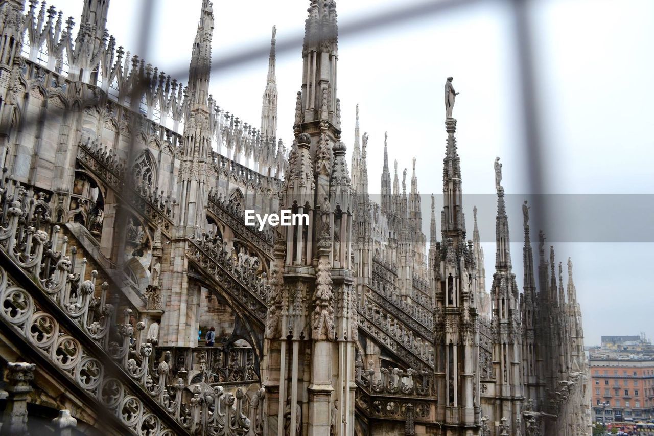 Low angle view of milan cathedral seen through metal grate