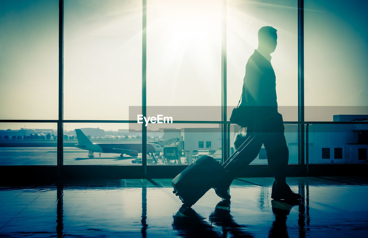 Businessman with luggage walking at airport