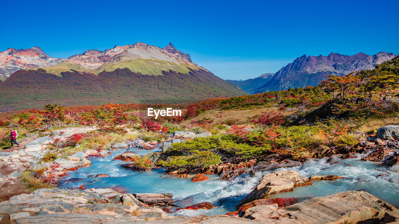 SCENIC VIEW OF LAKE AMIDST MOUNTAINS AGAINST BLUE SKY