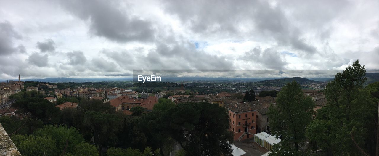 High angle view of buildings in town against cloudy sky