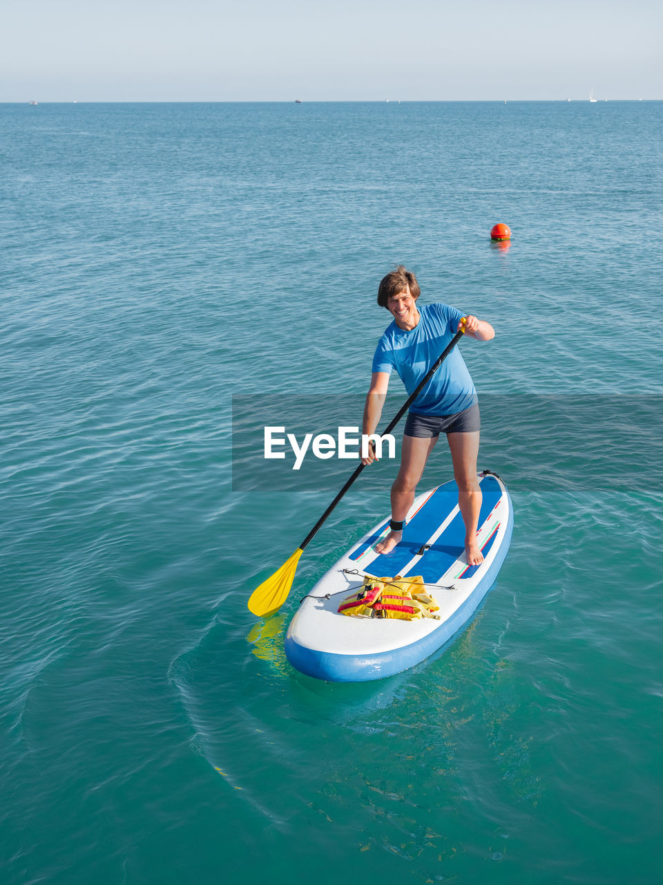 Handsome paddle boarder.sportsman paddling on stand up paddleboard.sup surfing. vacation on seaside.