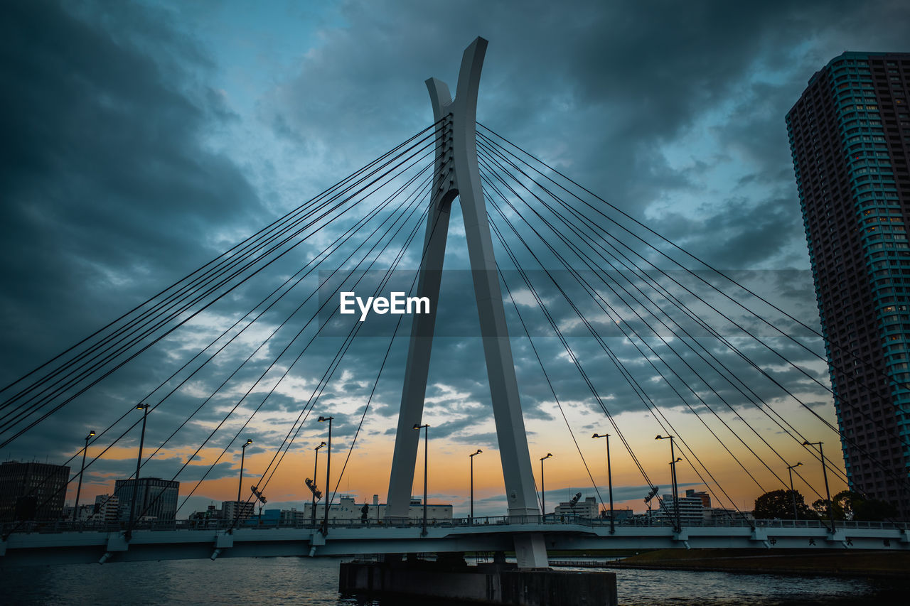 sky, architecture, built structure, cloud, city, landmark, cable-stayed bridge, bridge, transportation, water, cityscape, nature, travel destinations, skyscraper, building exterior, suspension bridge, reflection, dusk, no people, travel, building, landscape, horizon, evening, dramatic sky, outdoors, sunset, office building exterior, urban skyline, tourism, skyline, night, river, mode of transportation, city life, light, nautical vessel