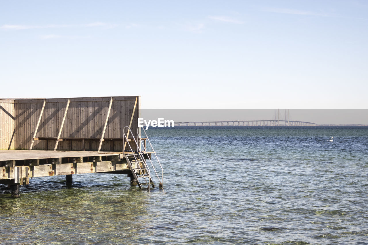 Jetty over sea against clear sky