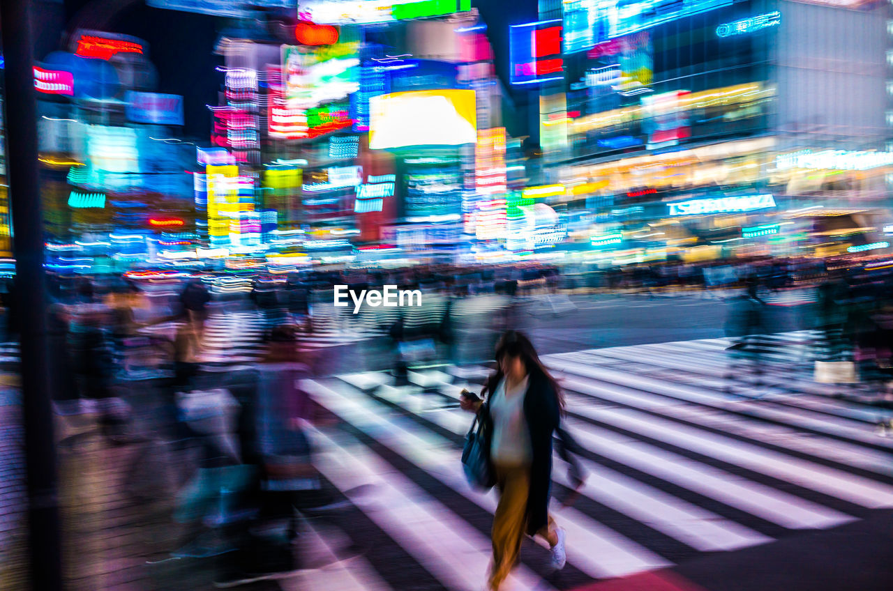 Blurred motion of people walking on street at night