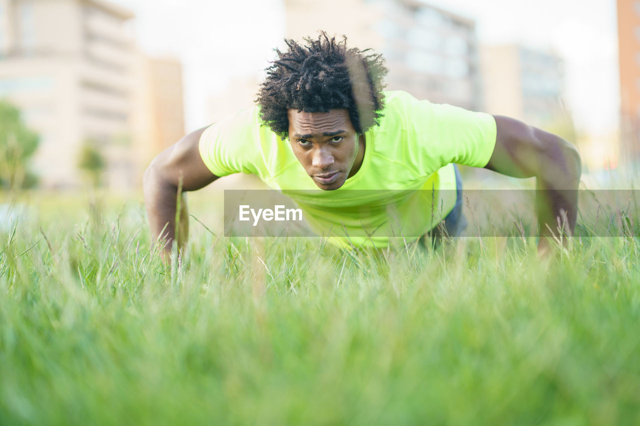 YOUNG MAN WEARING SUNGLASSES ON FIELD