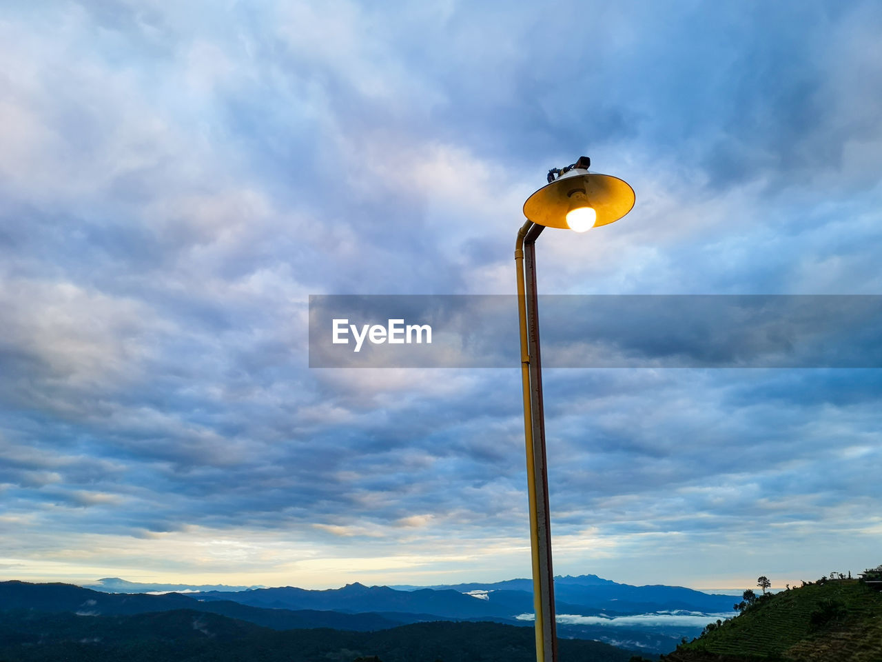 LOW ANGLE VIEW OF STREET LIGHT AGAINST CLOUDY SKY