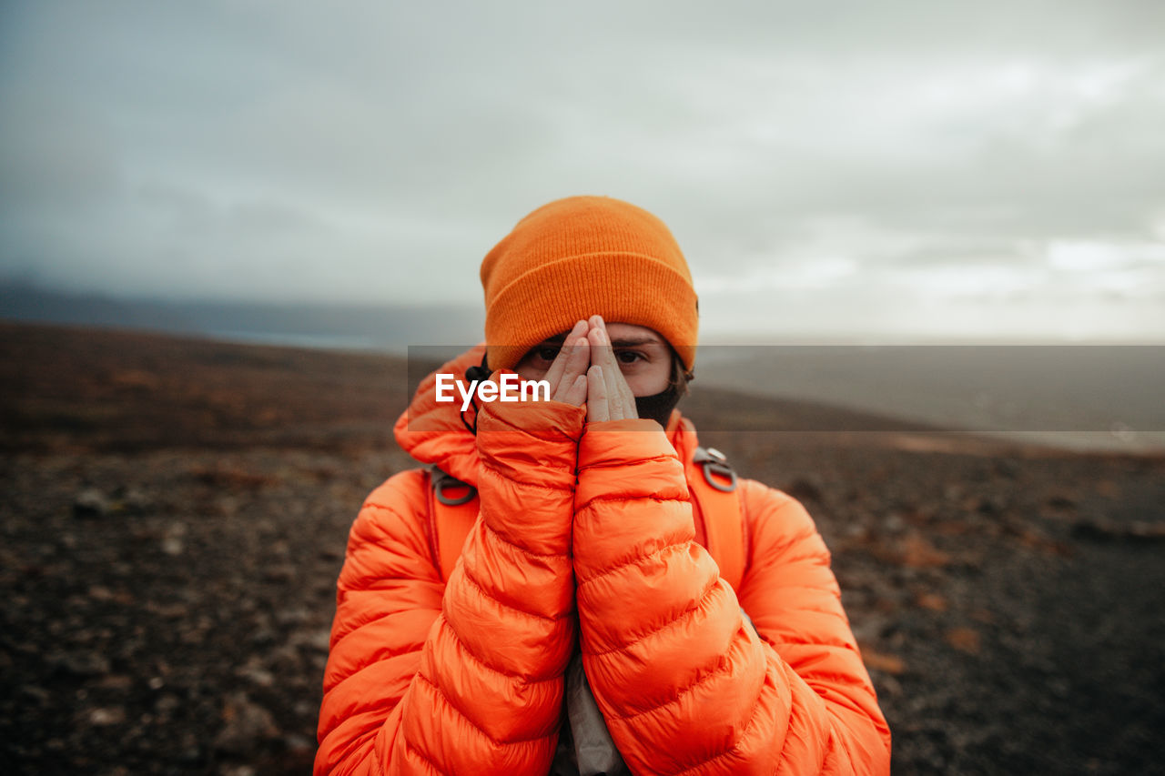 Young tourist near land and water on blurred background