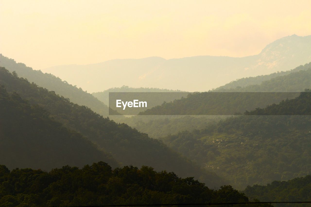 Scenic view of mountains against sky during foggy weather