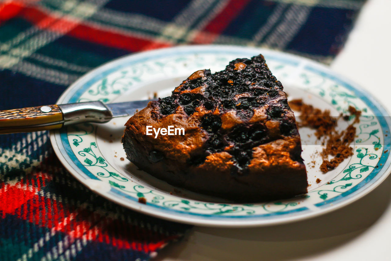 Close up piece of chocolate cake on a white plate with blue ornate patterns. brownie. cake.