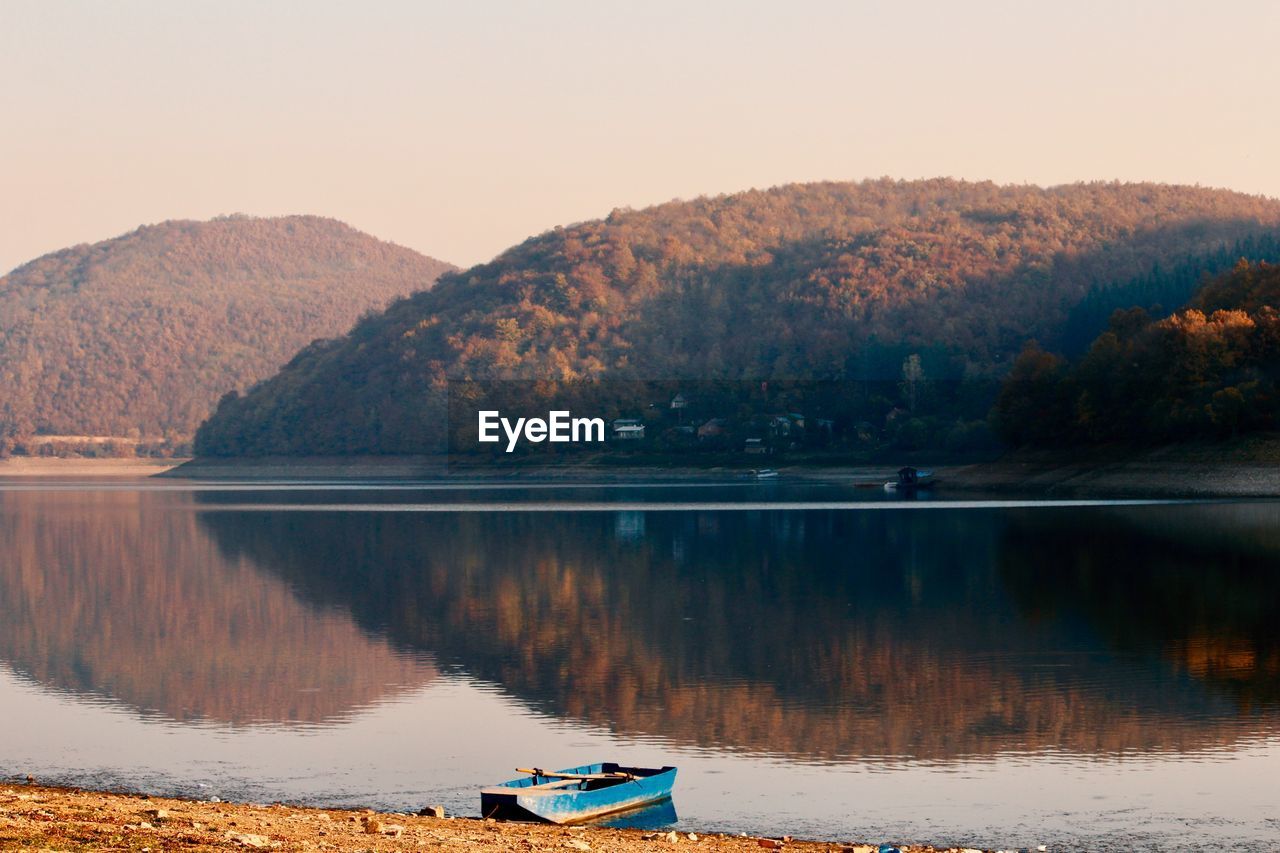 Scenic view of lake by mountains against sky