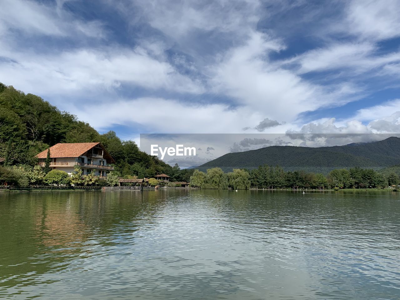 SCENIC VIEW OF LAKE BY HOUSES AGAINST SKY