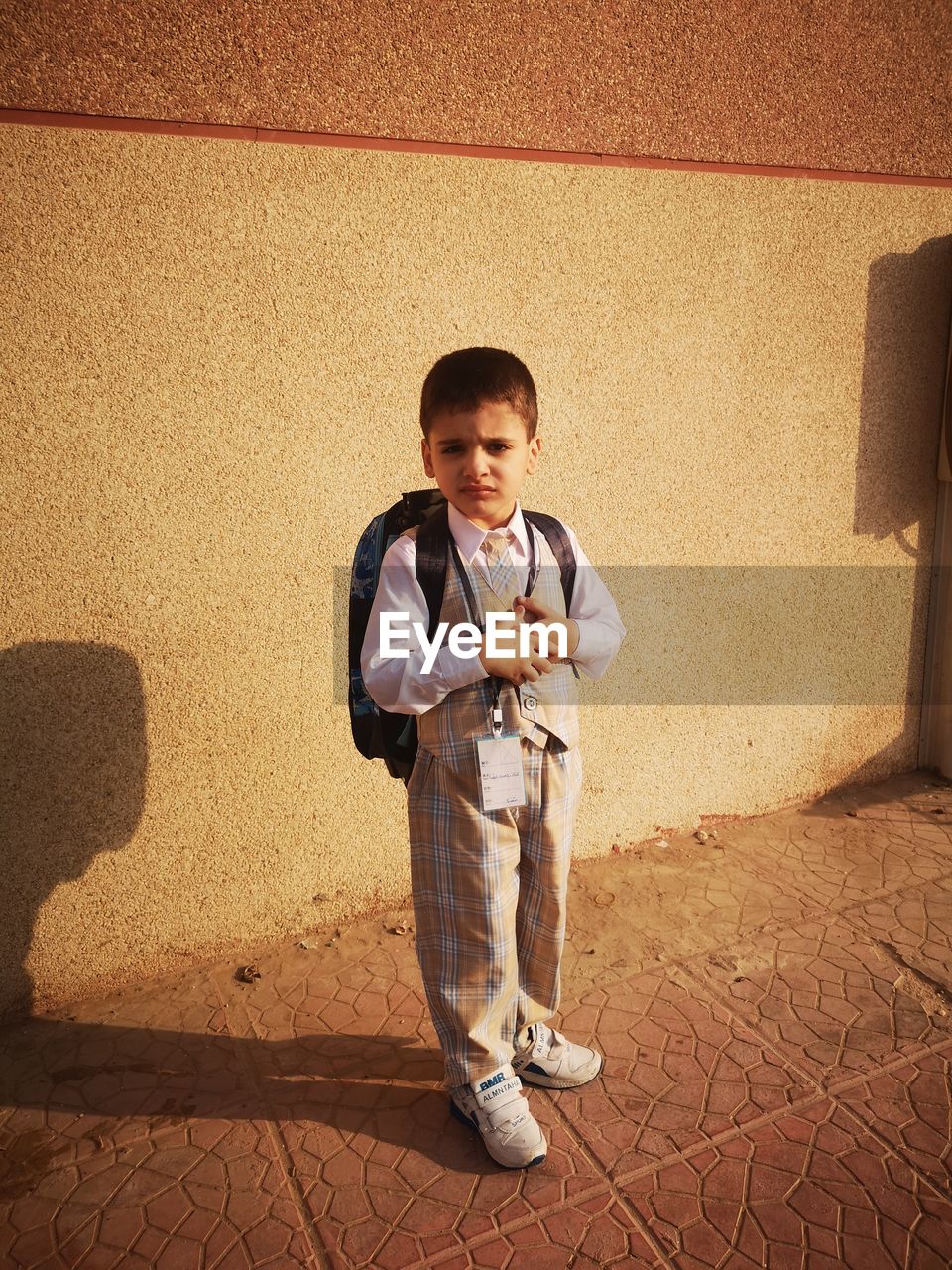 Portrait of boy standing against wall