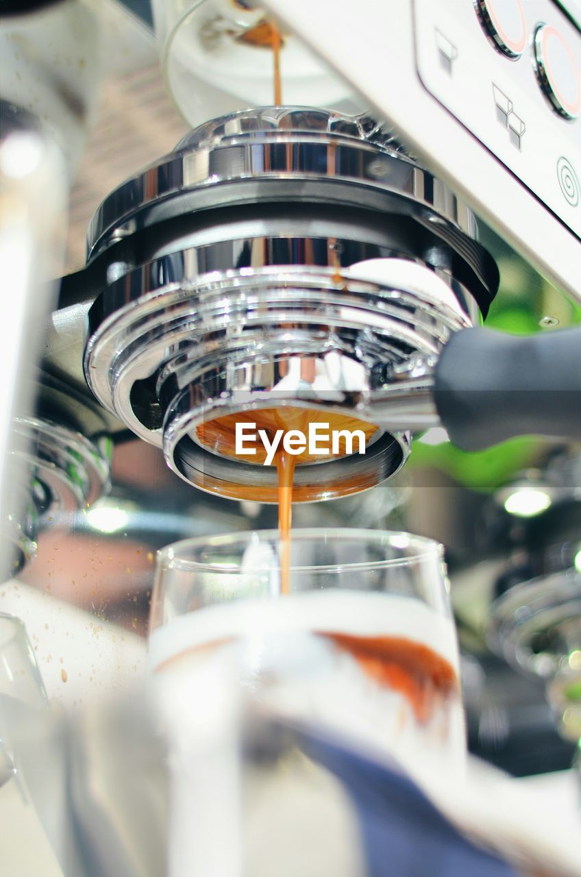 Close-up of espresso machine pouring coffee into cup