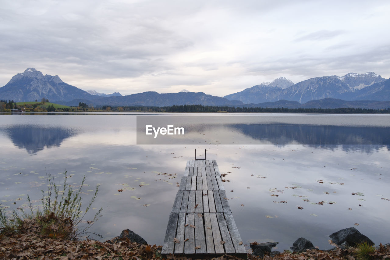 Scenic view of lake by mountains against sky