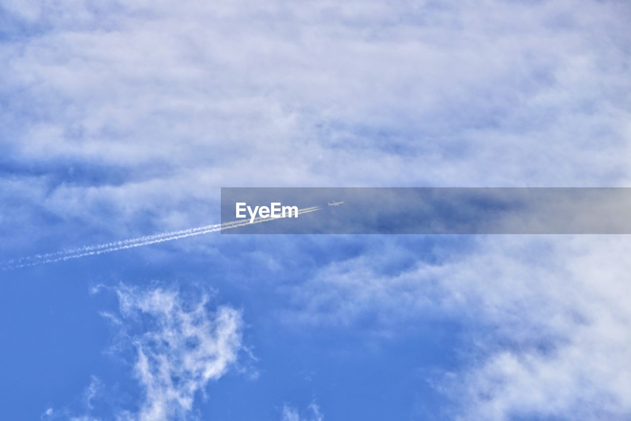 LOW ANGLE VIEW OF AIRPLANE FLYING AGAINST CLOUDY SKY