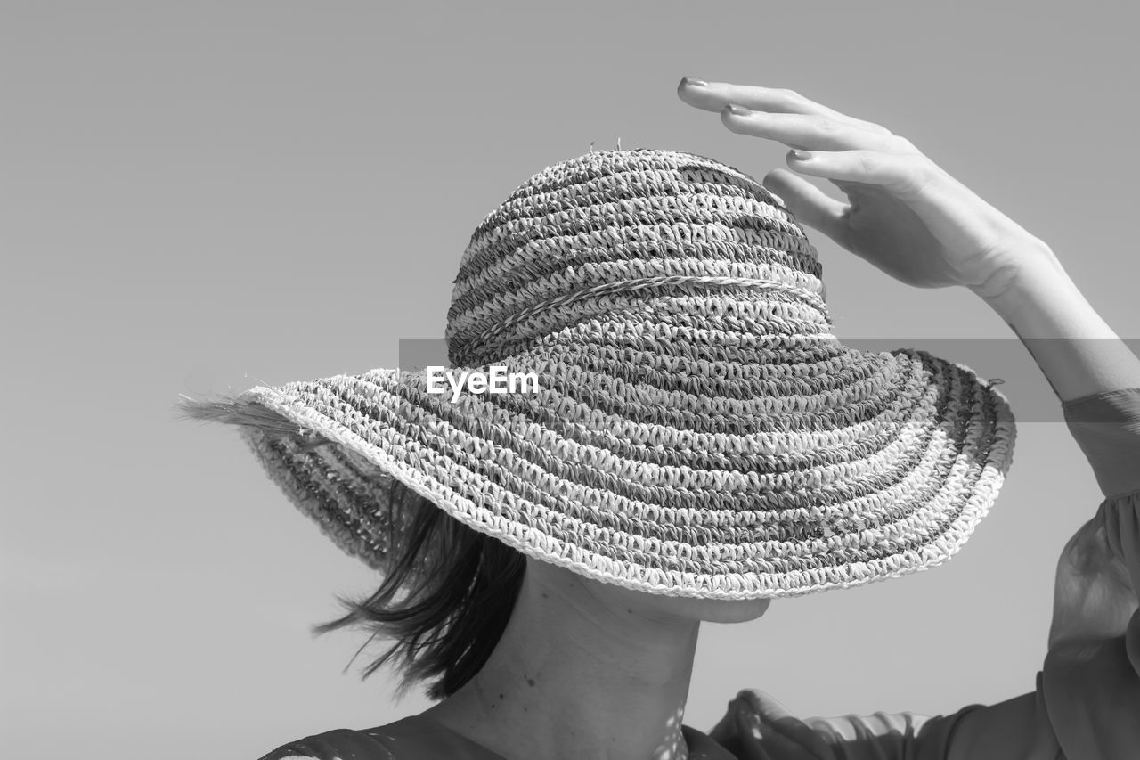 Rear view of woman wearing hat against clear sky