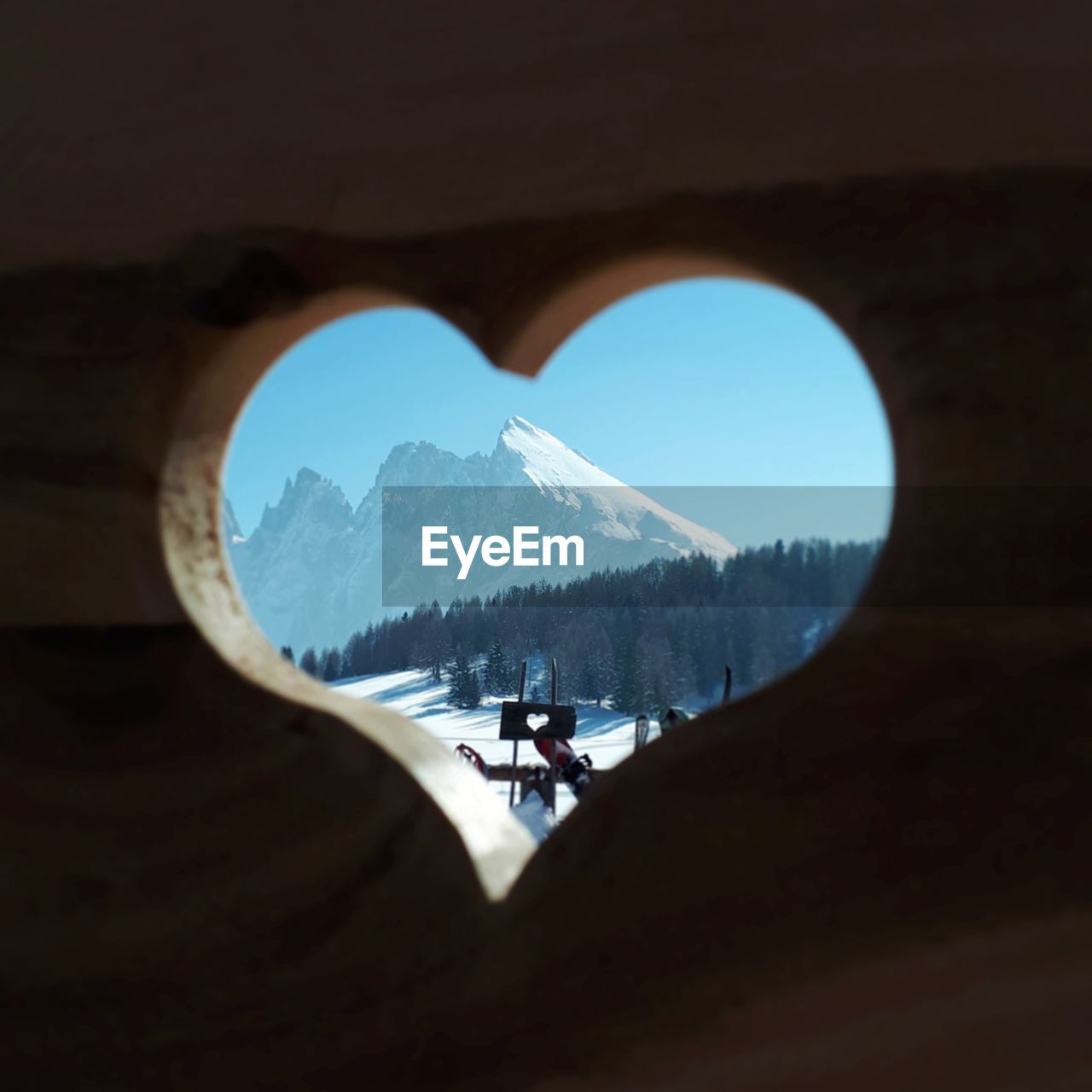 Scenic view of snowcapped mountains seen through heart shaped hole