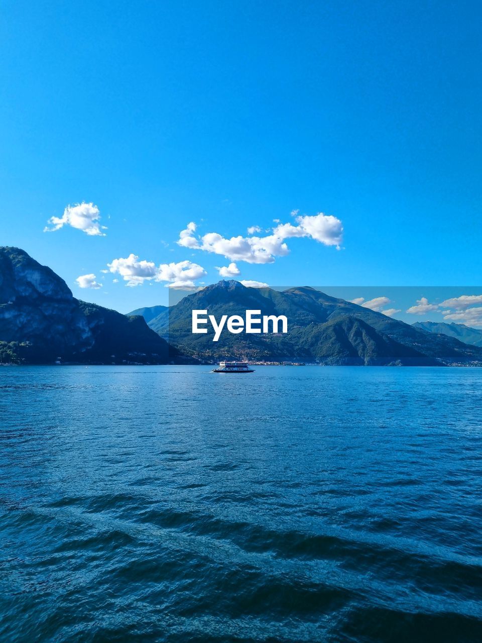 Scenic view of sea and mountains against blue sky