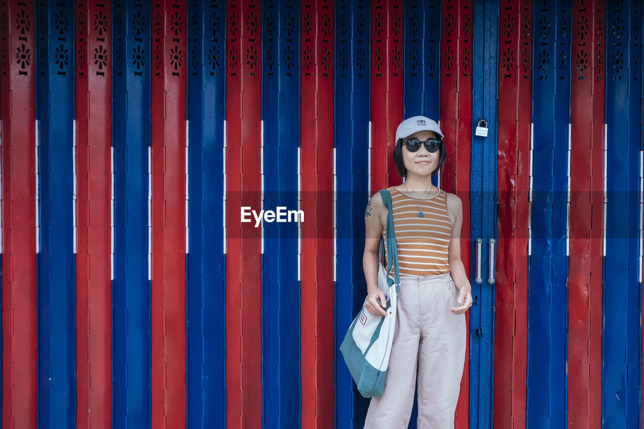 full length of woman standing against wall