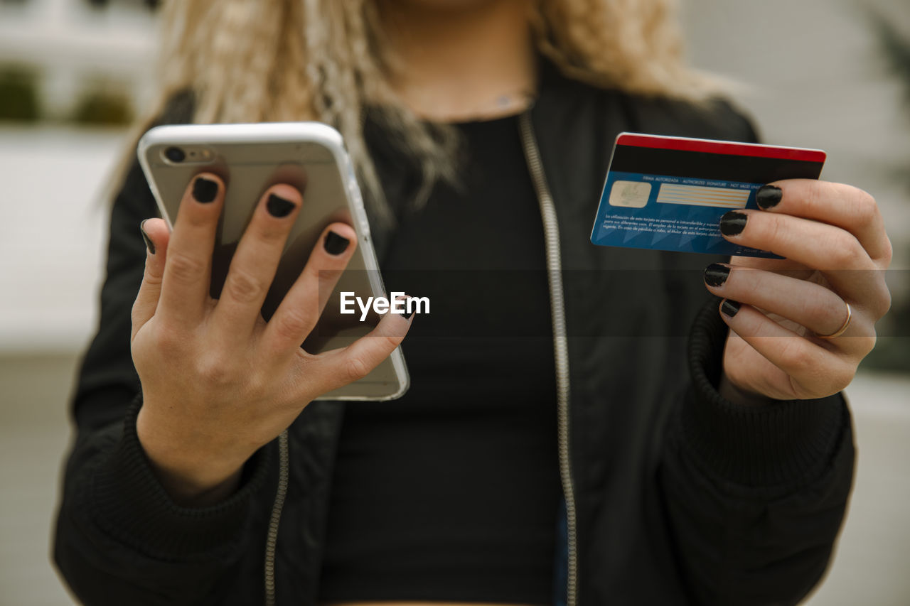 Young woman shopping with smart phone and credit card