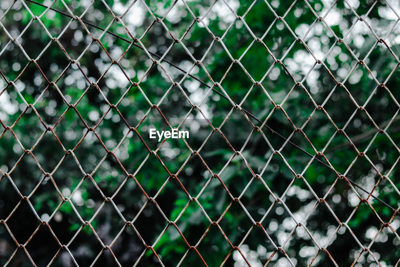 FULL FRAME SHOT OF CHAINLINK FENCE SEEN THROUGH METAL WIRE