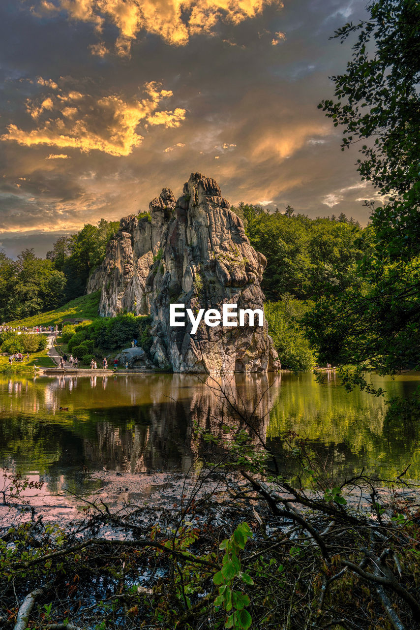 Scenic view of rock by lake against sky