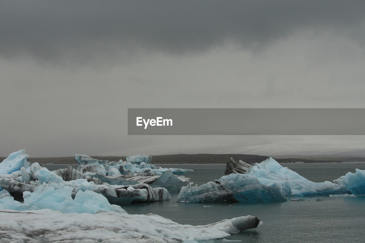 FROZEN LAKE AGAINST SKY DURING WINTER