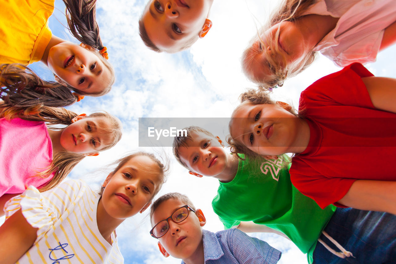 Low angle view of friends against sky