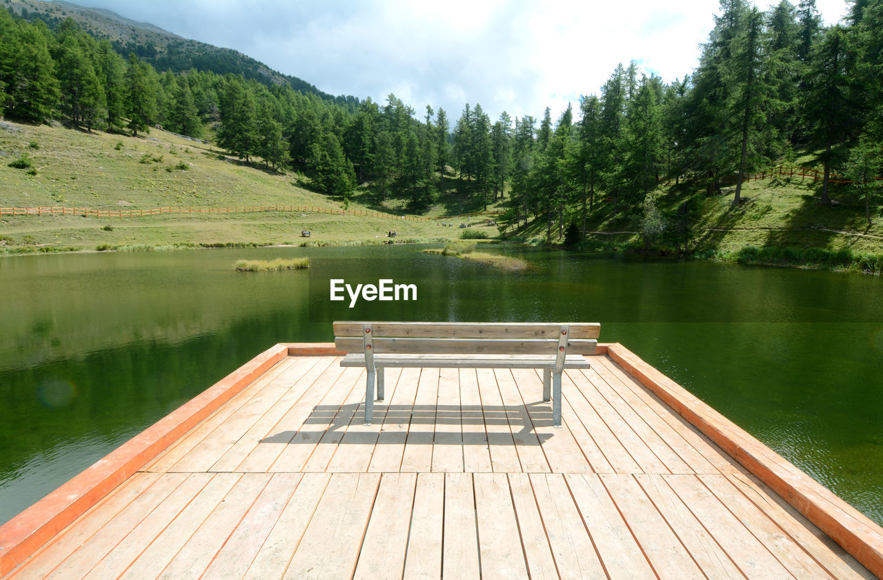 Scenic view of lake by trees against sky