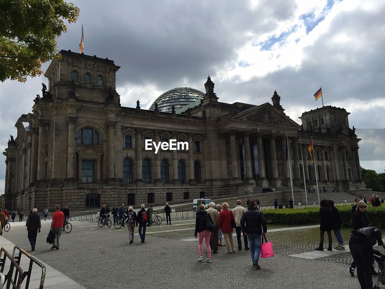 Tourists at the reichstag against cloudy sky