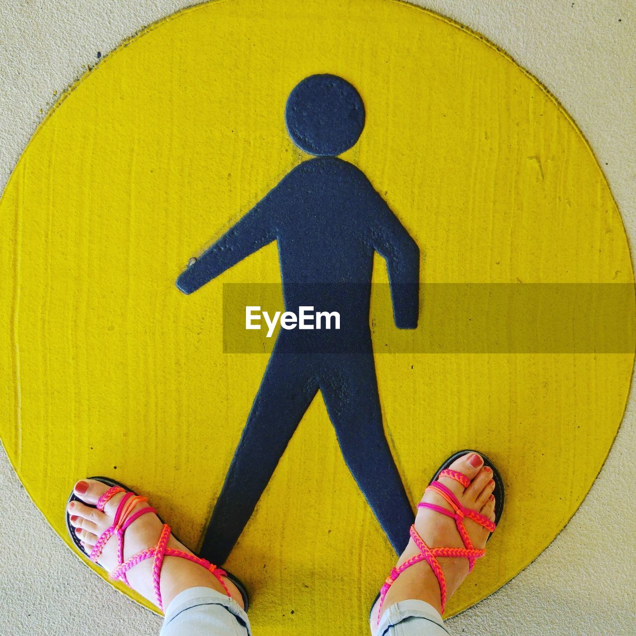 LOW SECTION OF PERSON STANDING ON YELLOW UMBRELLA