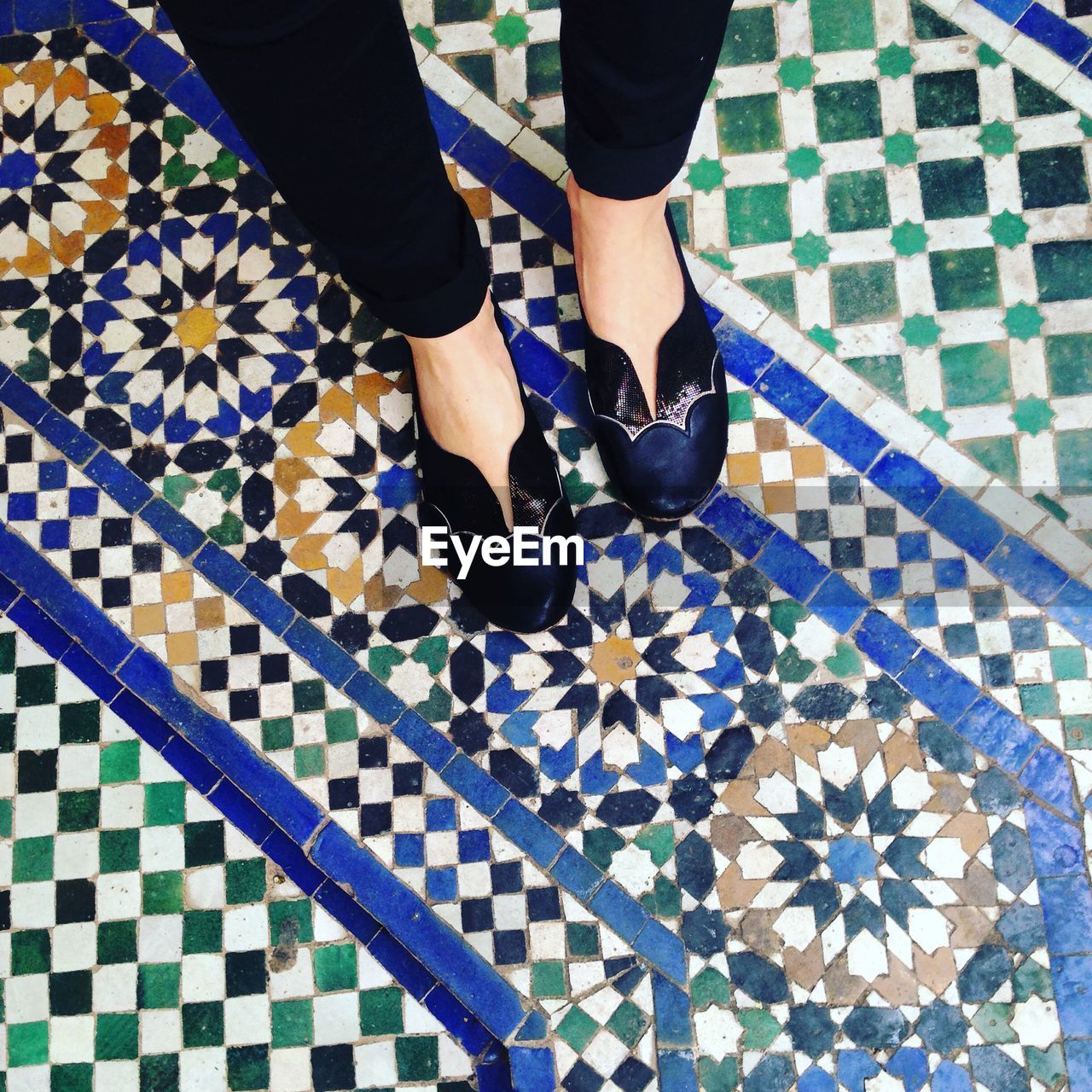 LOW SECTION OF MAN STANDING ON TILED FLOOR