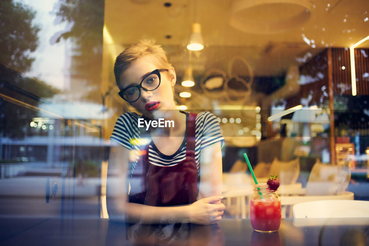 Woman sitting by window at restaurant