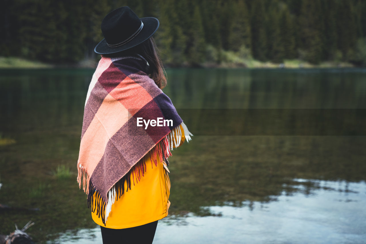 Side view of woman standing by lake