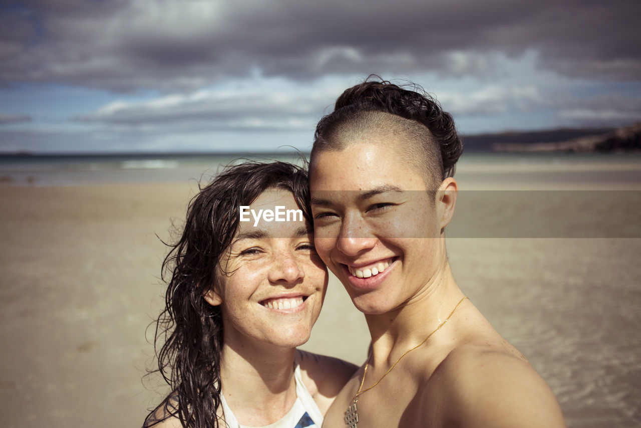 Romantic happy selfie by lesbian couple on beach