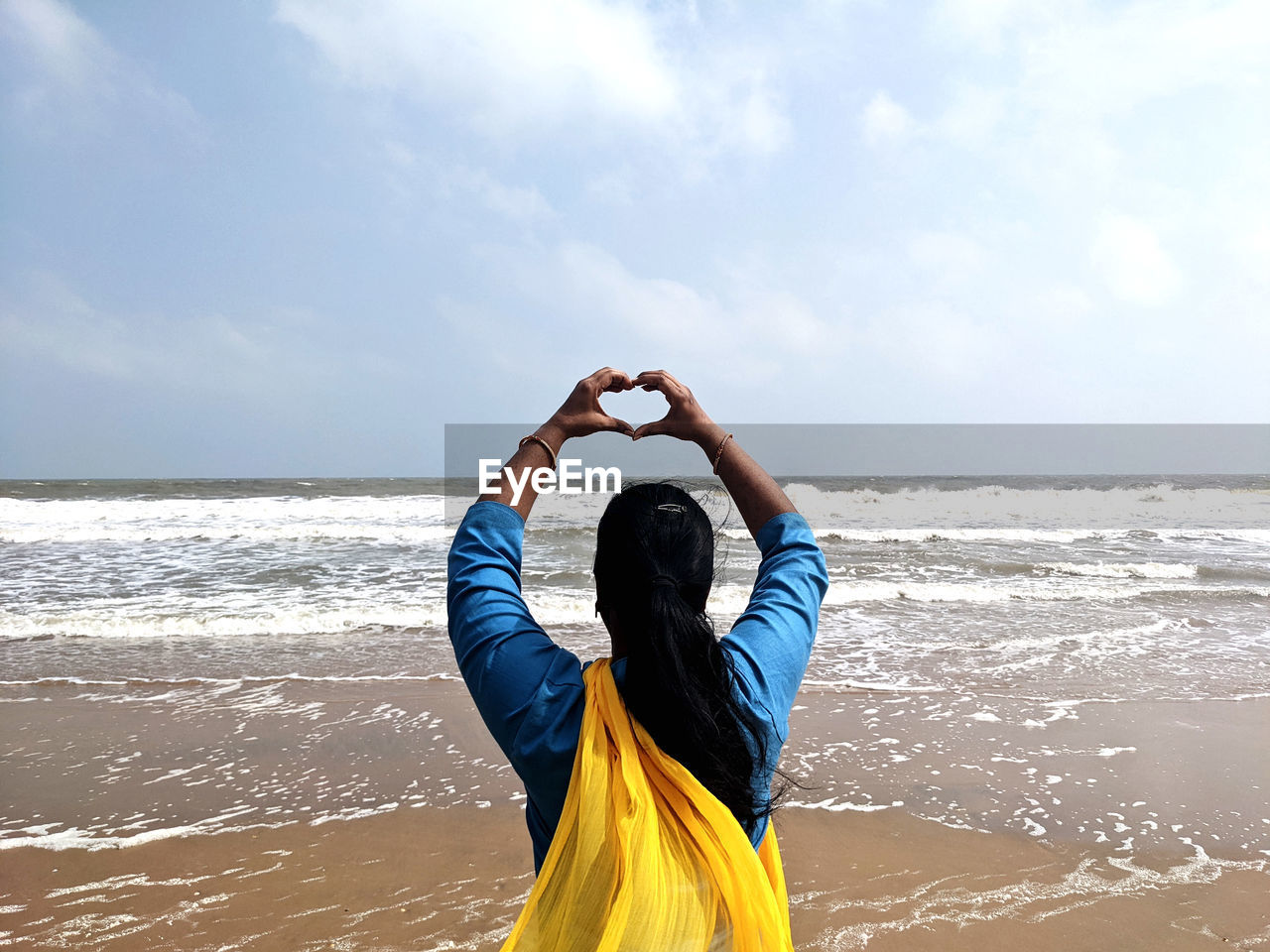 water, sea, sky, land, beach, one person, nature, adult, rear view, horizon over water, horizon, ocean, vacation, sports, leisure activity, clothing, motion, day, holiday, arm, cloud, wave, trip, person, lifestyles, blue, outdoors, beauty in nature, women, young adult, arms raised, sunlight, tranquility, standing, limb, relaxation, scenics - nature, copy space, sand, waist up, human limb, activity, hand, summer, casual clothing, travel, coast