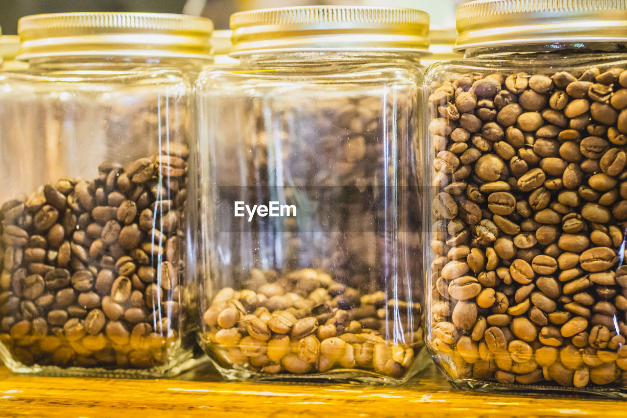 Close-up of coffee beans in glass containers on table