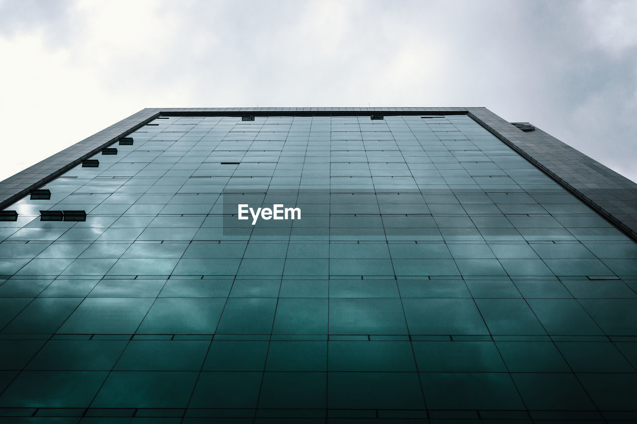 LOW ANGLE VIEW OF GLASS BUILDING AGAINST SKY