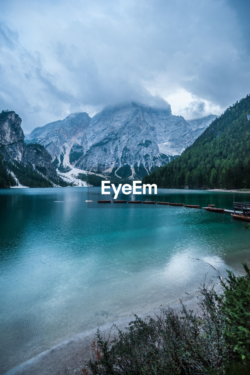 Scenic view of lake by snowcapped mountains against sky