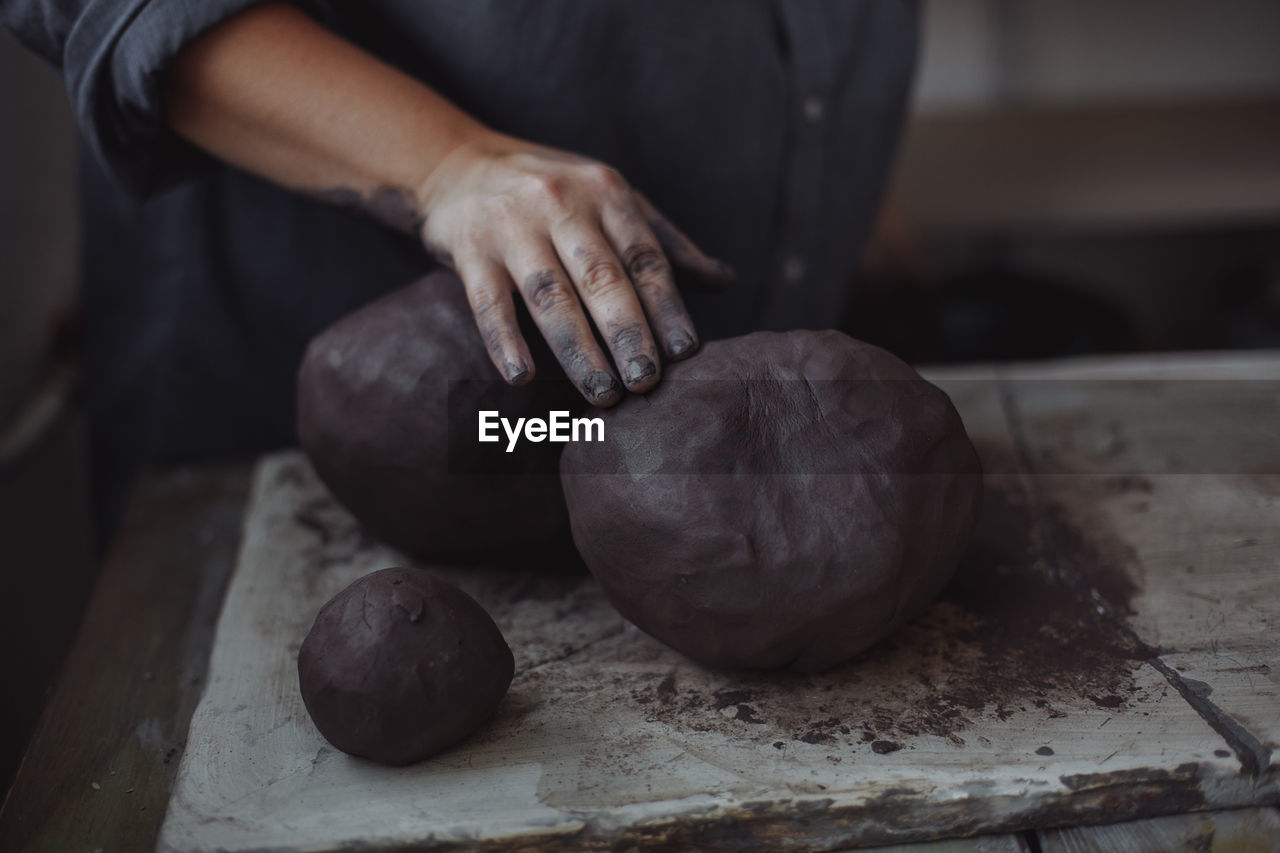 Middle-aged woman working in a pottery studio with clay