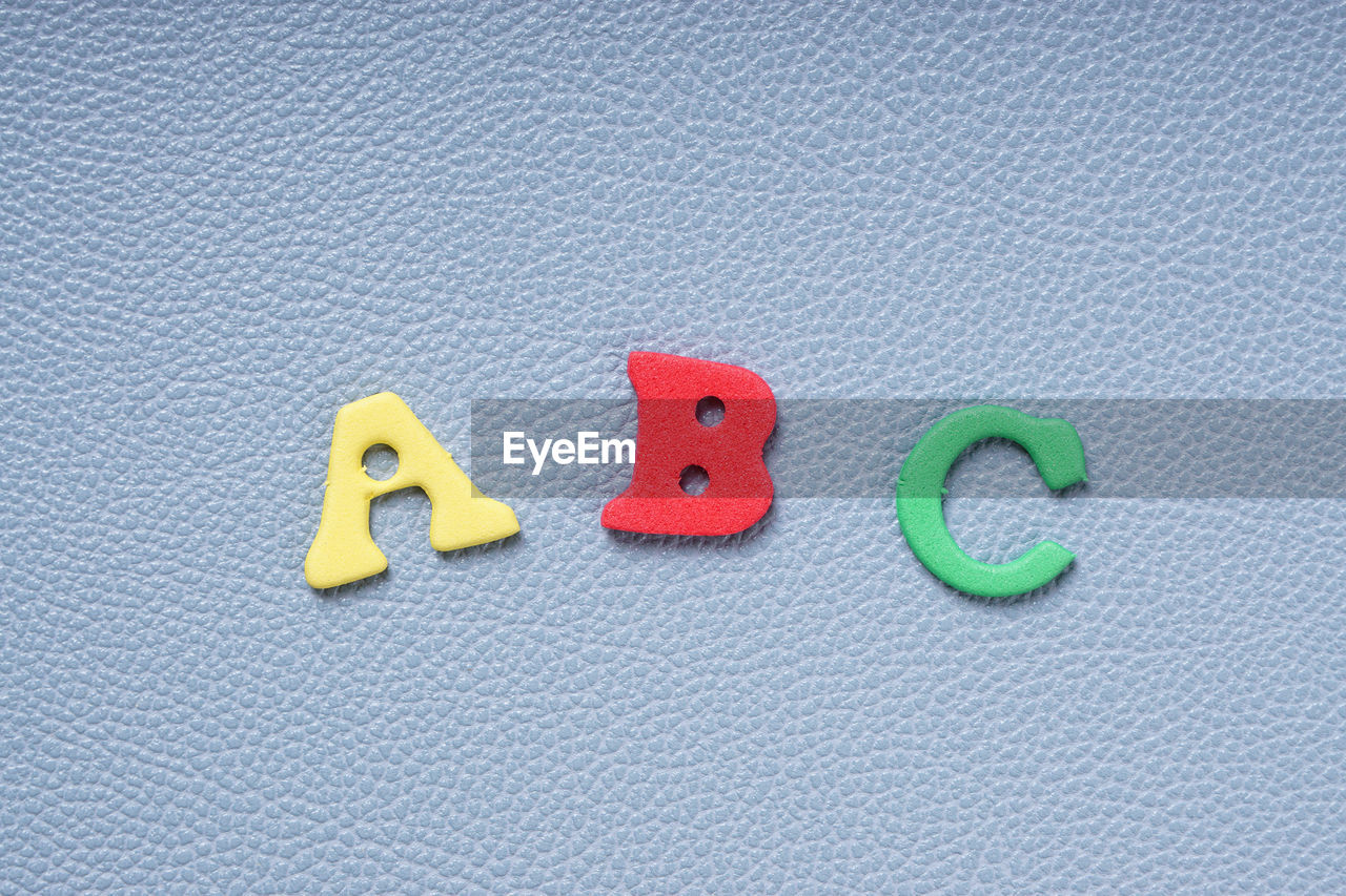 Directly above shot of colorful foam alphabets on gray table