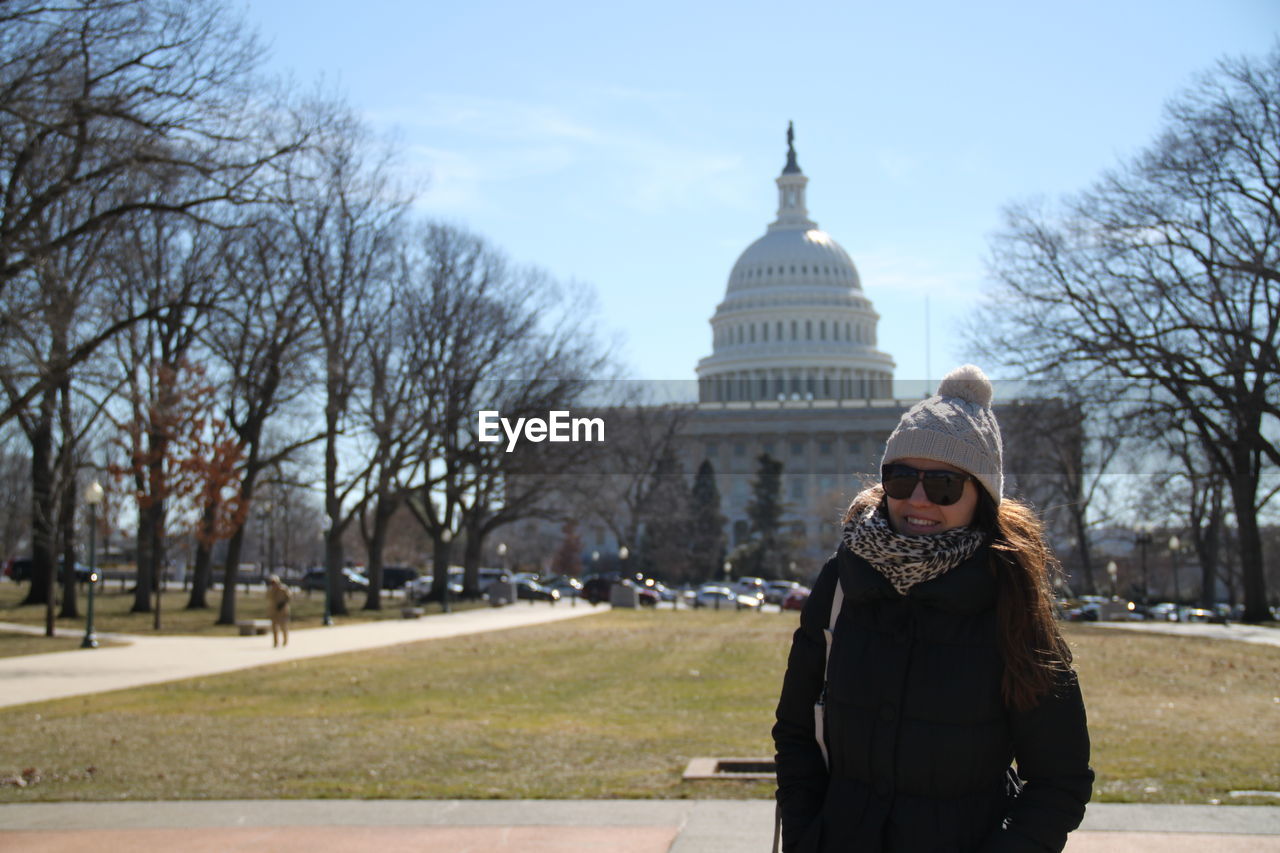 Happy woman standing against united states capitol