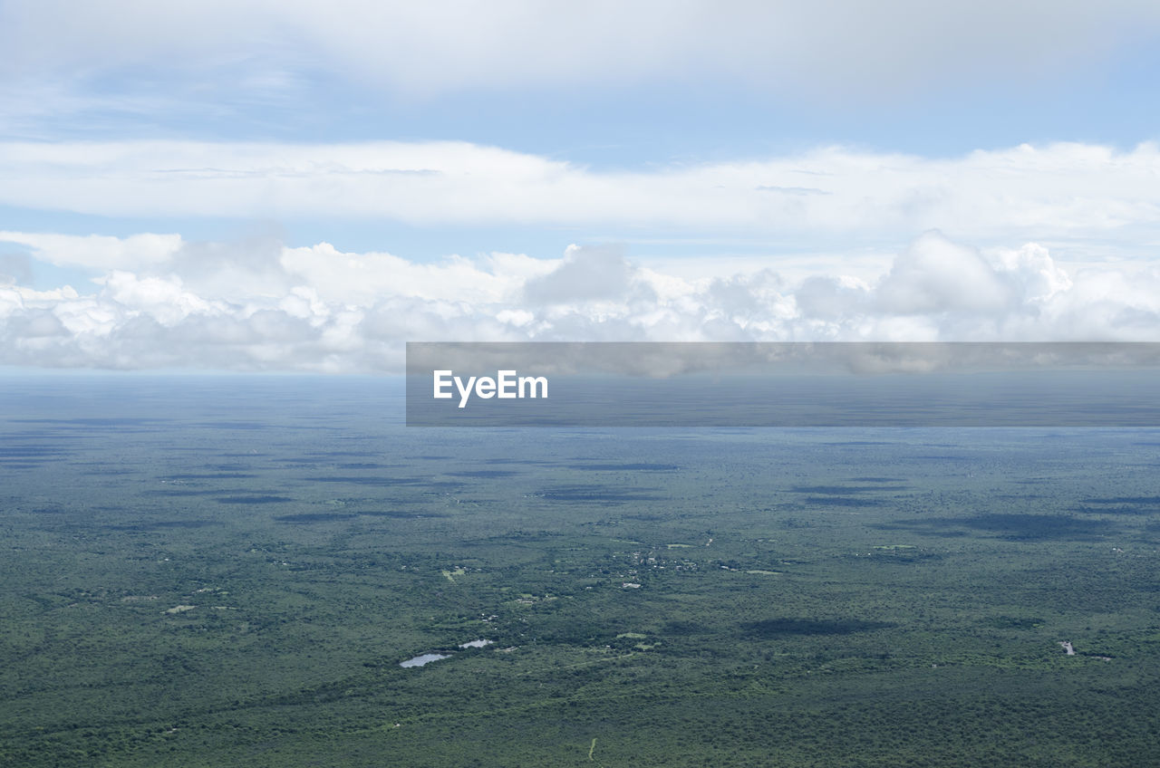 HIGH ANGLE VIEW OF SEA AND LAND AGAINST SKY