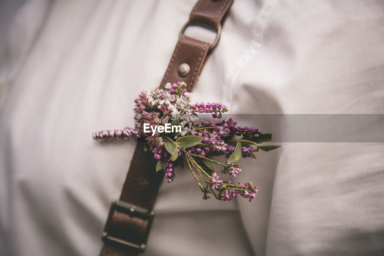 Cropped image of person with suspenders and flowers