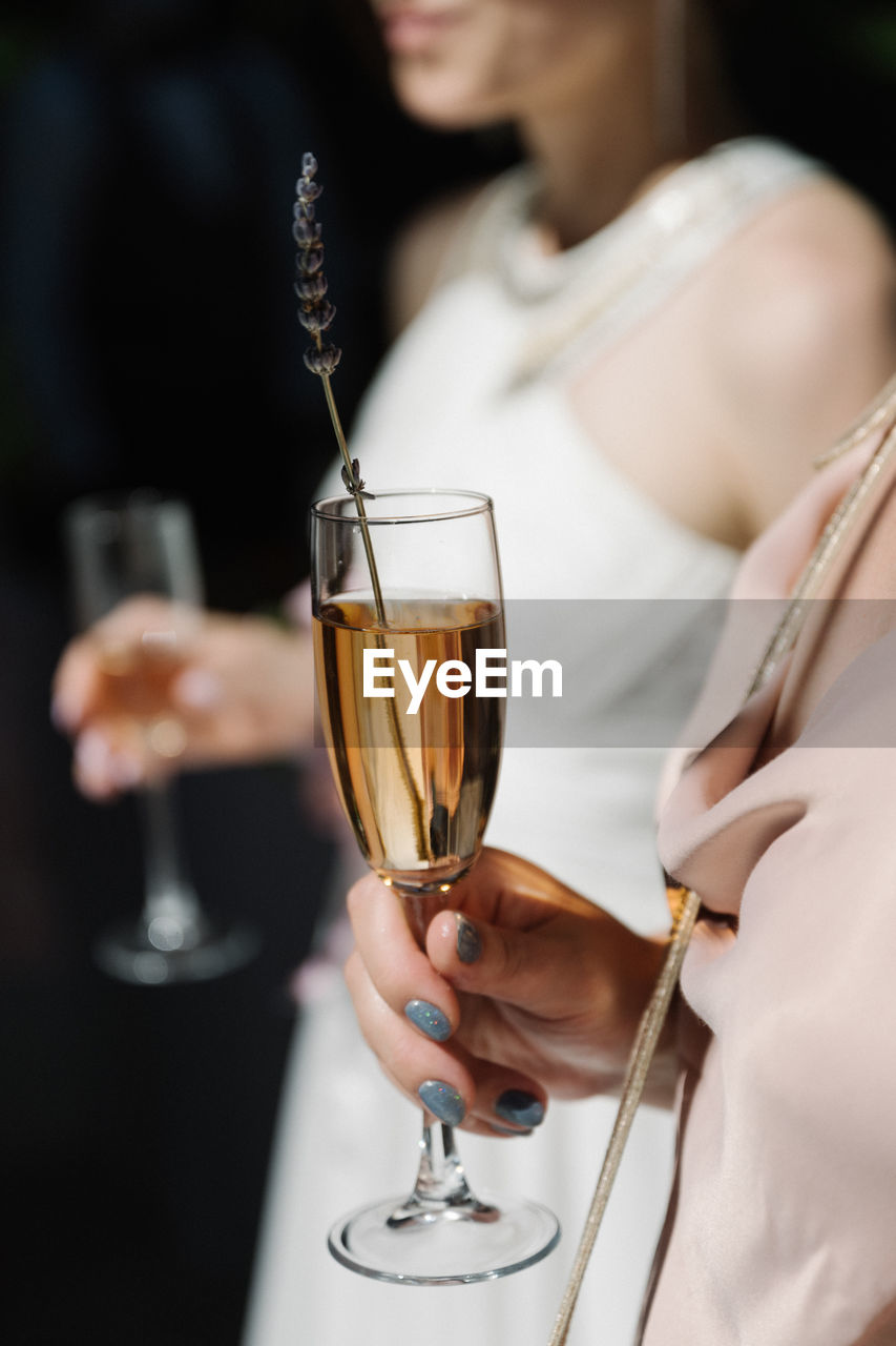 Midsection of woman holding wineglass