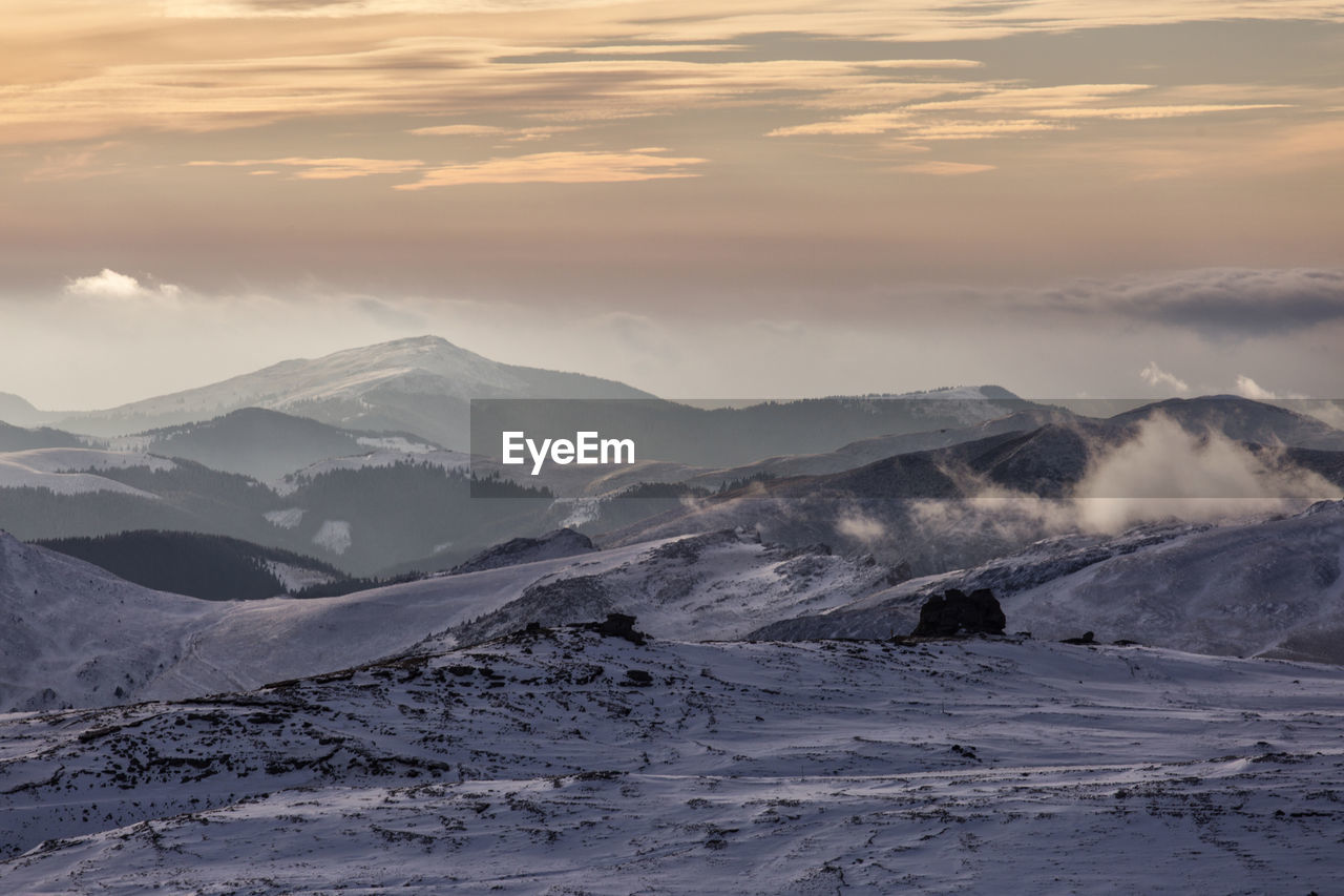 Scenic view of snowcapped mountains against sky during sunset